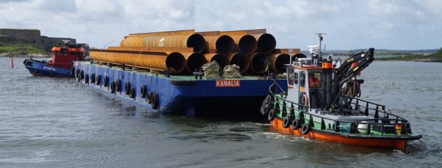 Bogserbåtarna Rygene och Hector transporterar rör ombord på pråmen Kanalia.