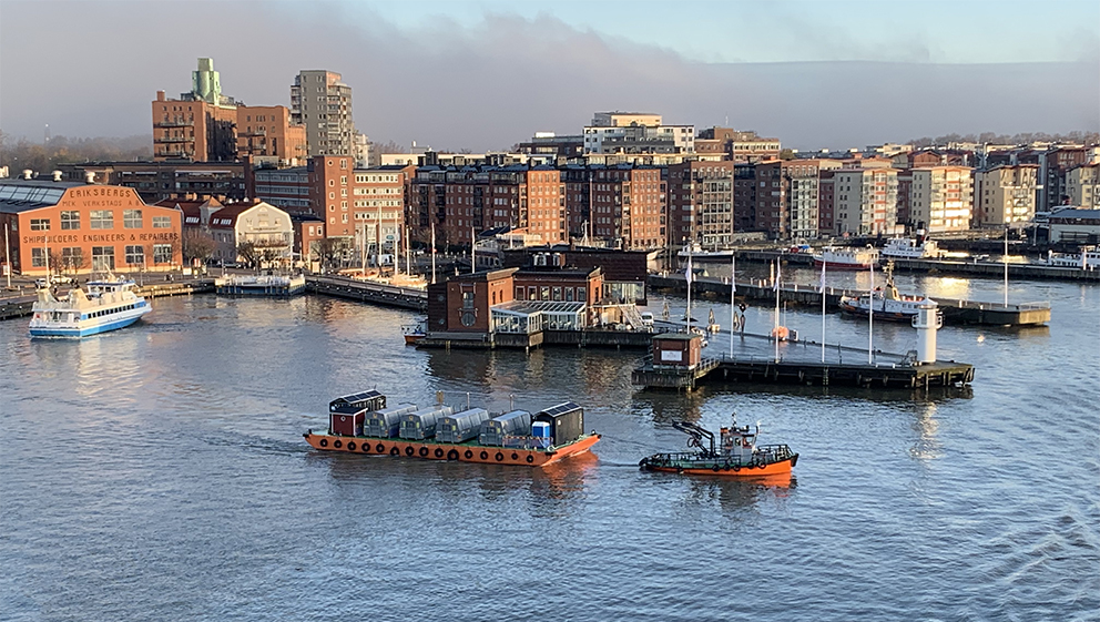 Pråmkompaniets bogserbåt Hector bogserar återvinningspråmen Melina genom Göteborg.
